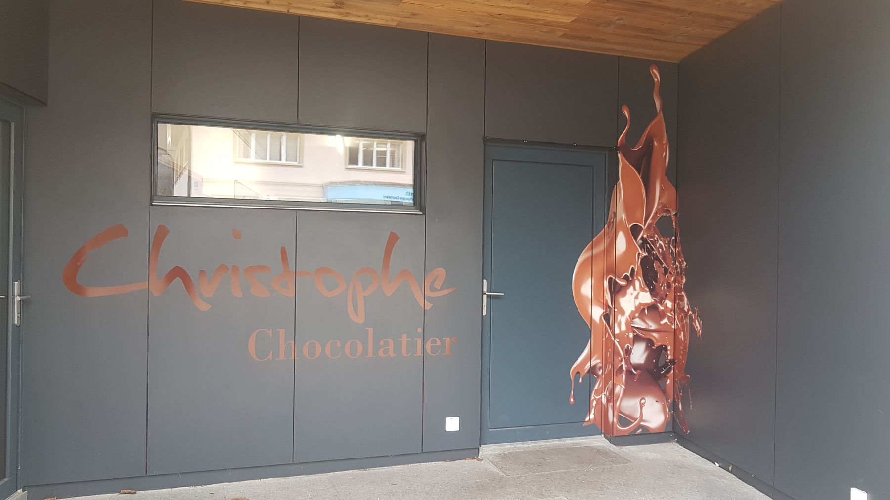 Entrée de la boutique Christophe Chocolatier à Courtelary, avec la tache de chocolat